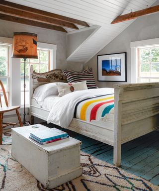 bedroom with pitched ceiling and white bed and American blanket