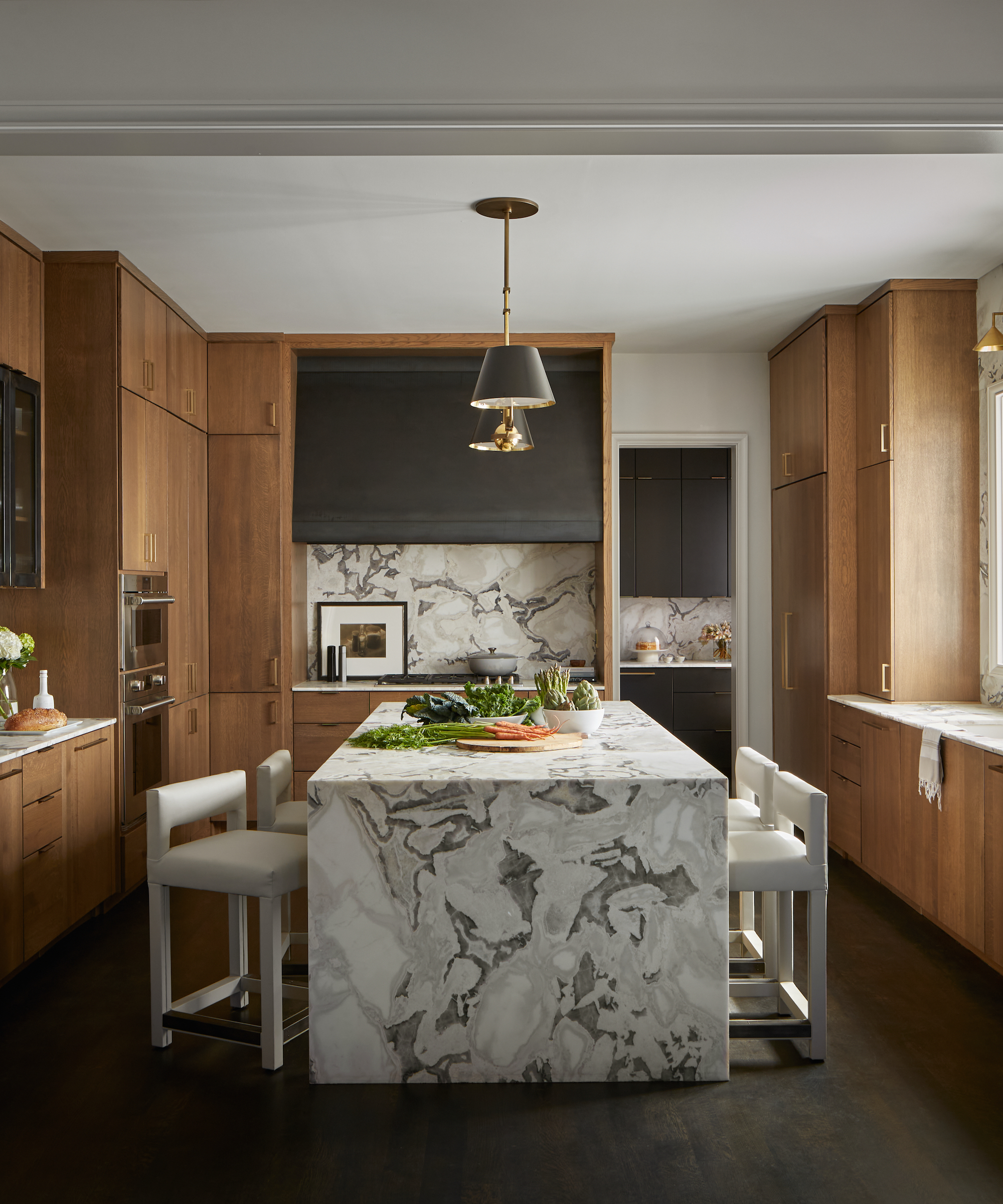 quartzite island with stools on two opposite sides in timber kitchen