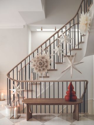 The curved staircase with decorations going up the bannister