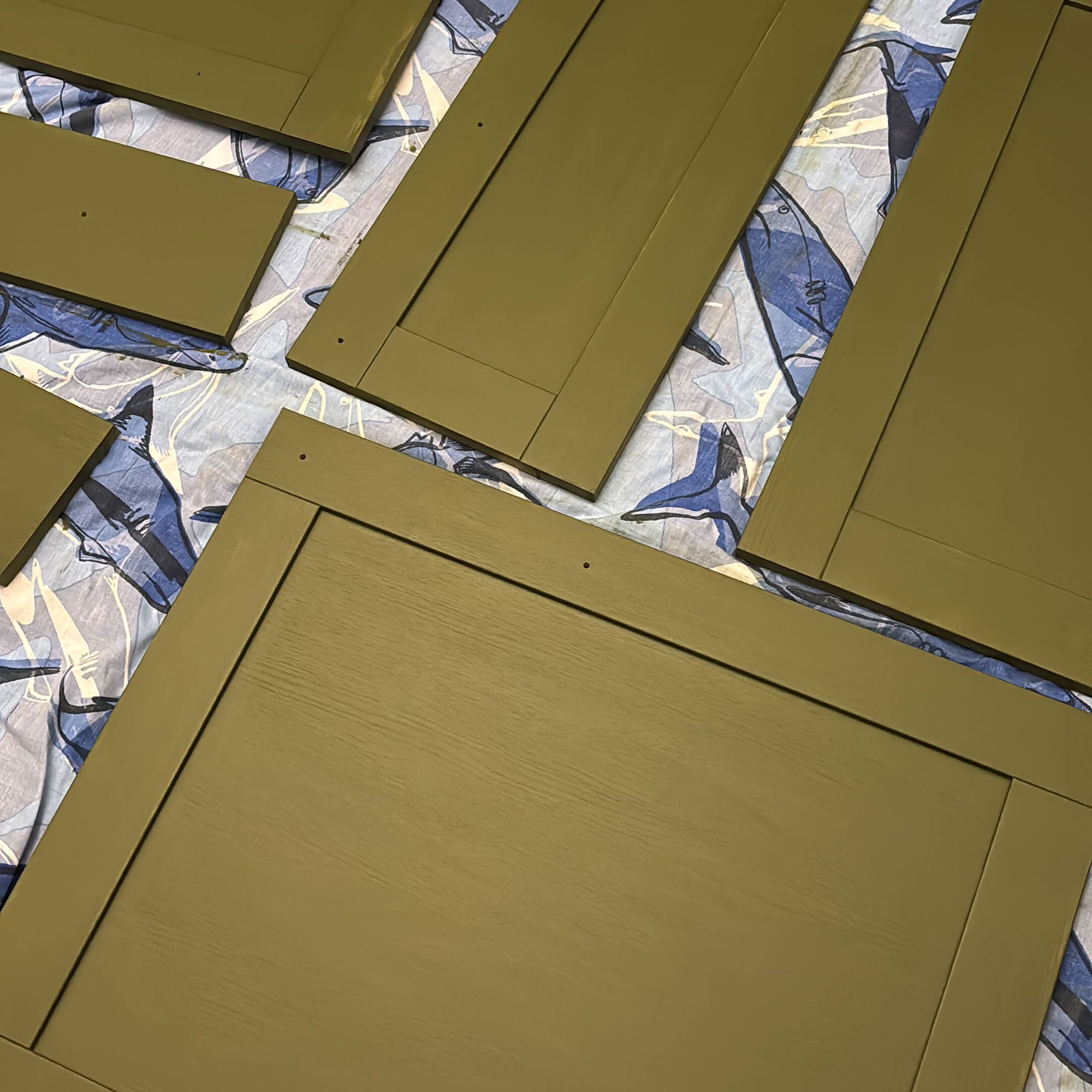 Green painted kitchen with gold handles and white countertops