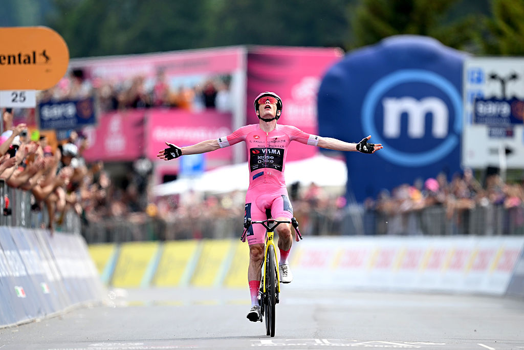 Vingegaard celebrates with both arms out in the pink jersey after winning stage 20 of the Giro d'Italia