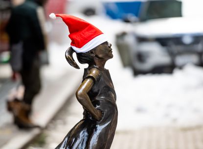 The Fearless Girl statue wears a Santa hat outside the New York Stock Exchang