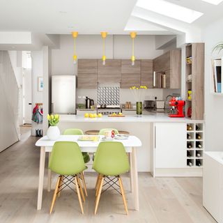 kitchen area with dining table and chairs with wooden flooring