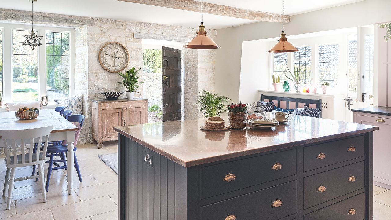 farmhouse kitchen with navy blue island unit and stone walls