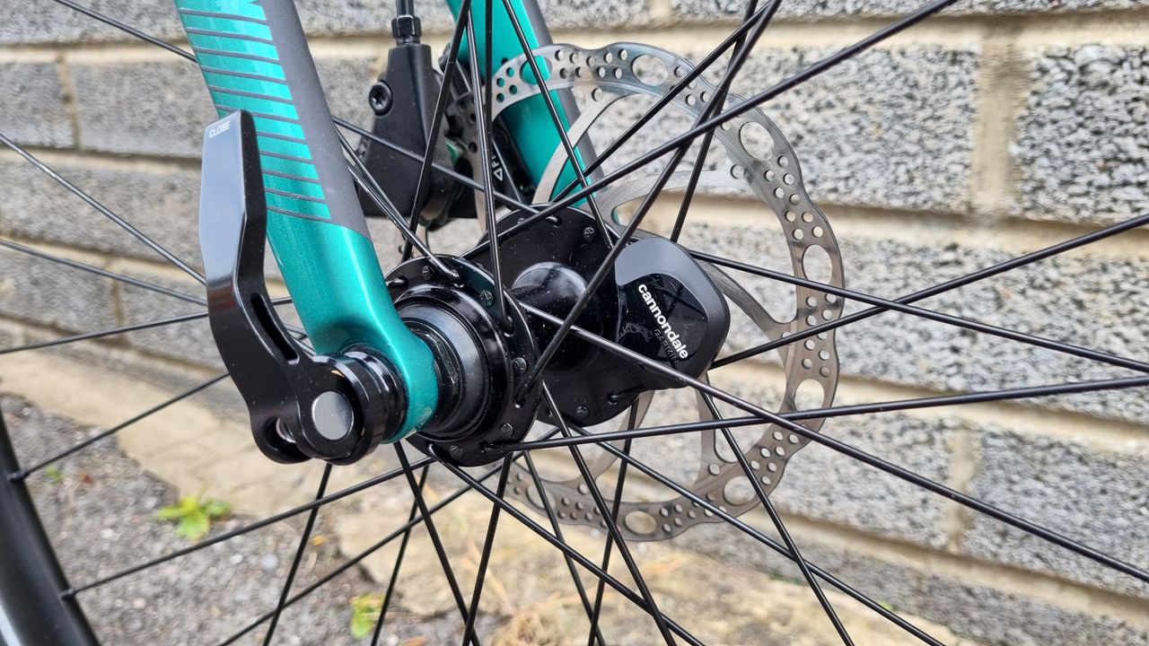 A close up of a bike wheel hub with a black Cannondale wheel sensor affixed in place