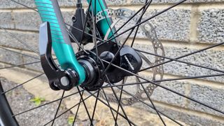 A close up of a bike wheel hub with a black Cannondale wheel sensor affixed in place