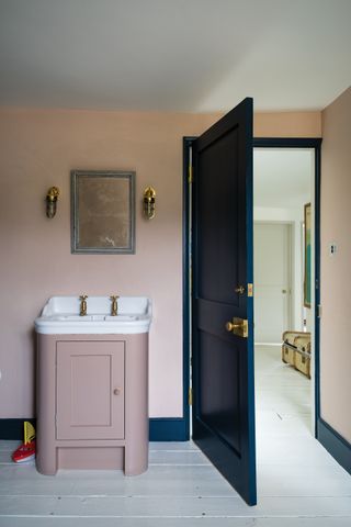 pink bathroom with basin and dark blue door