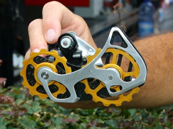 This is essentially what's hiding beneath that massive rear derailleur cage - an oversized 13T upper pulley and a 15T lower one. The thinking is that it reduces drivetrain friction and it's an idea that's gaining popularity in the peloton. SRAM is currently evaluating the concept for production.
