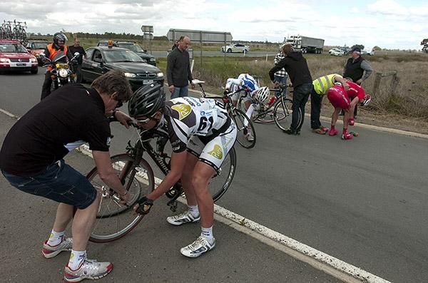Pure Tasmania &amp; Deloitte team-manager Mark Matthews changes a wheel for Danny Pulbrook after a pile-up on stage four.