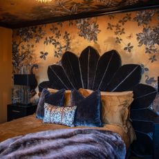 bedroom with statement wallpaper and blue velvet bed