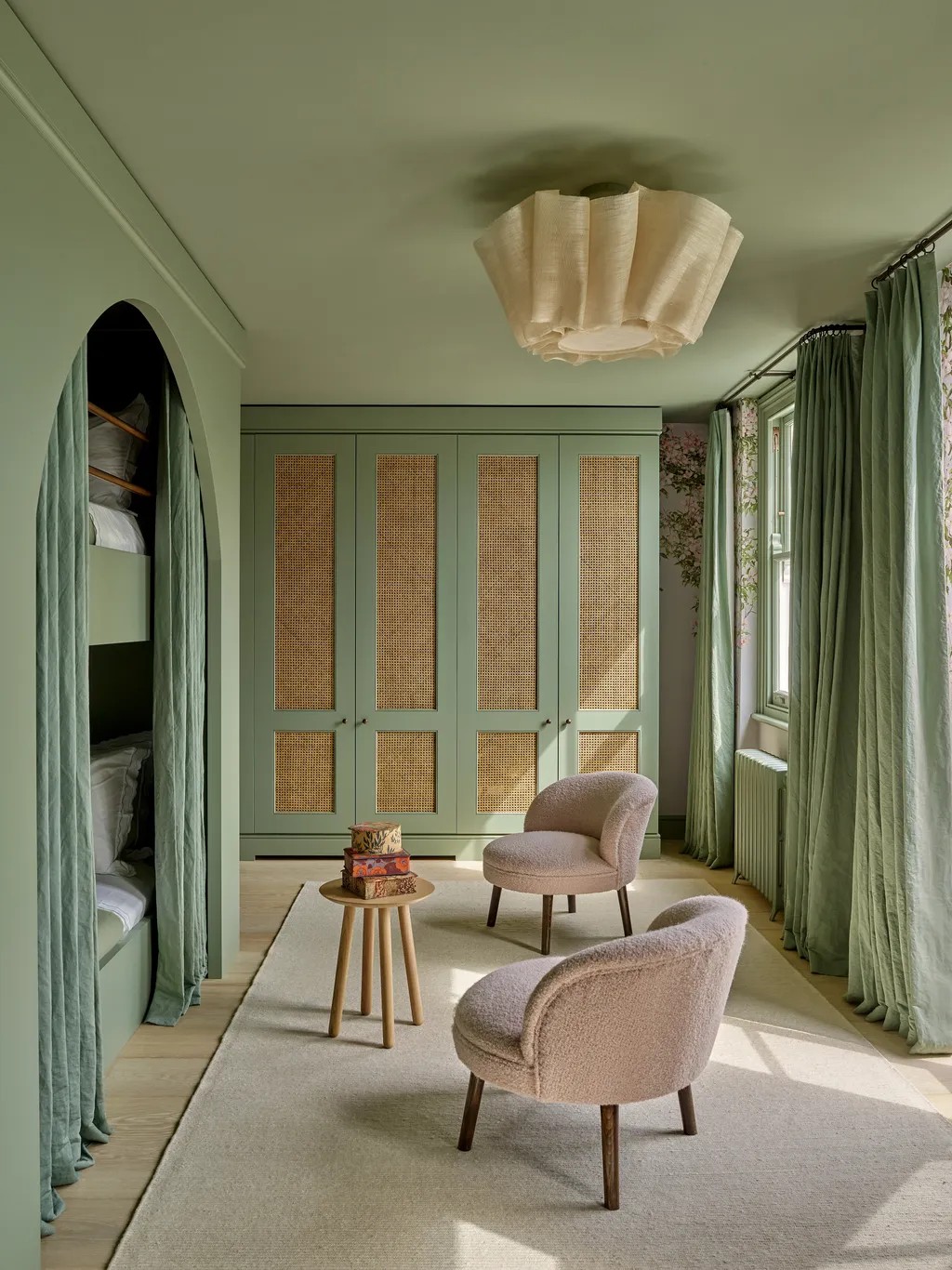 Beautifully decorated interiors with pastel-toned walls, sculptural seating, statement lighting, wood furniture upholstered in colorful fabric, and lots of natural light.