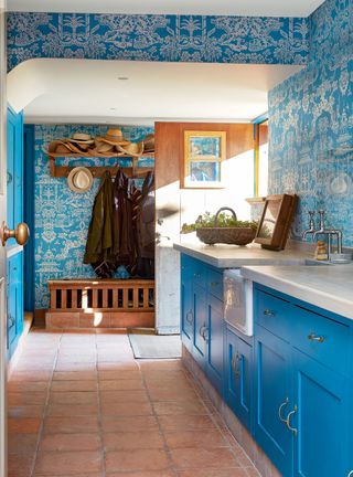 blue kitchen with rustic floor and cerulean wallpaper