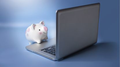 A piggy bank appears to be working on a laptop.