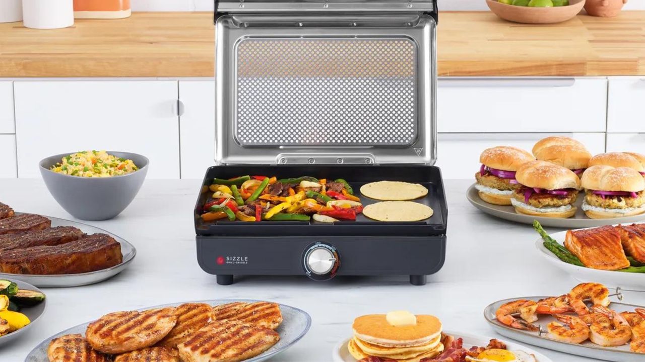 Ninja Sizzle™ Smokeless Electric Indoor Grill &amp; Griddle with prepared food on kitchen countertop