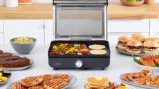 Ninja Sizzle™ Smokeless Electric Indoor Grill & Griddle with prepared food on kitchen countertop