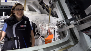 Kat Coderre, the principal investigator for Lockheed Martin’s Stemrad vest, wears the radiation-blocking vest inside NASA’s Orion spacecraft. Orion will carry two dummies on the Artemis I mission, and the dummies will test out the new vest.