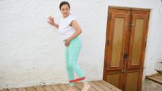 Woman exercising with resistance band on decking outside