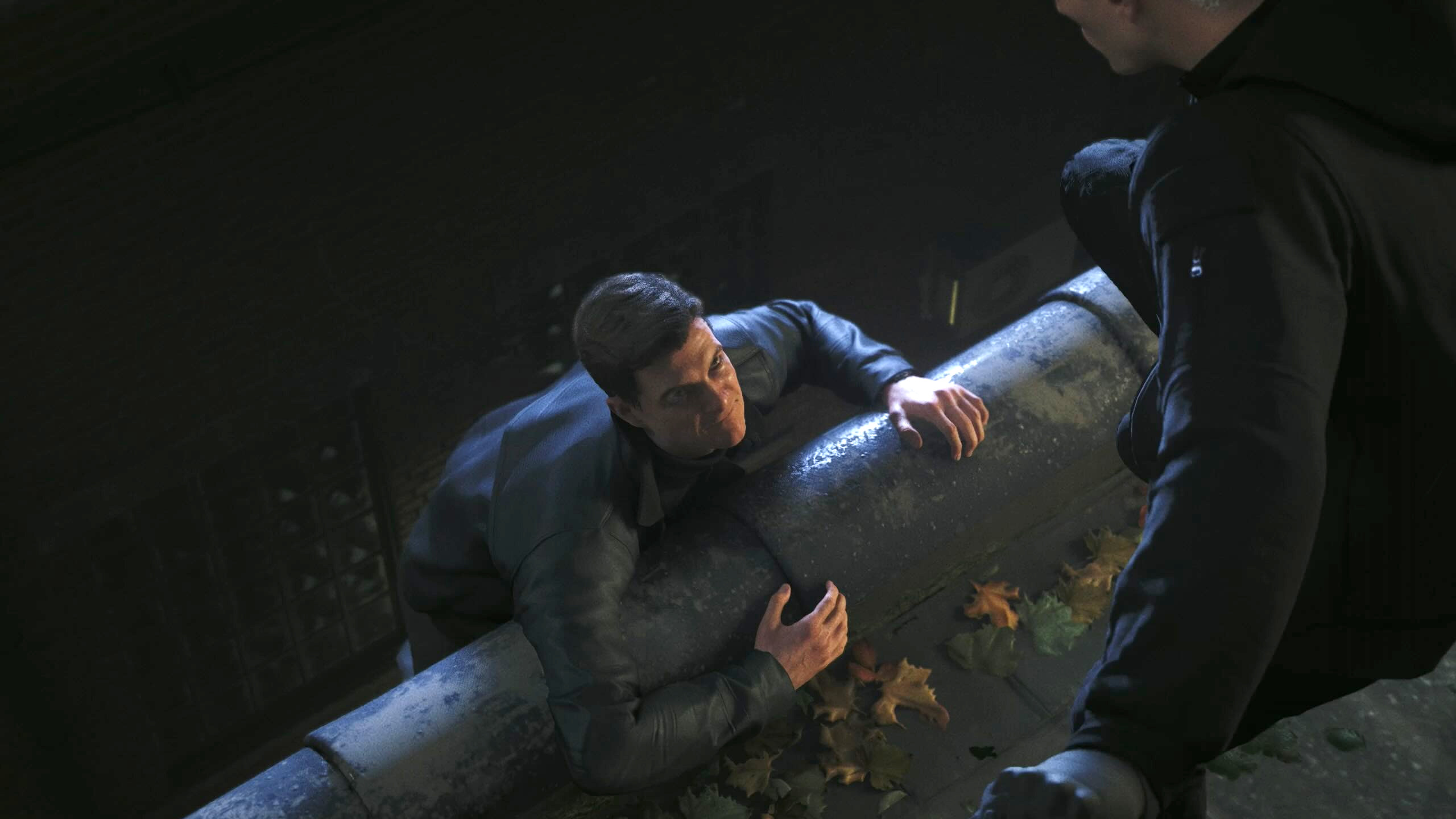 Bond hangs off a roof.