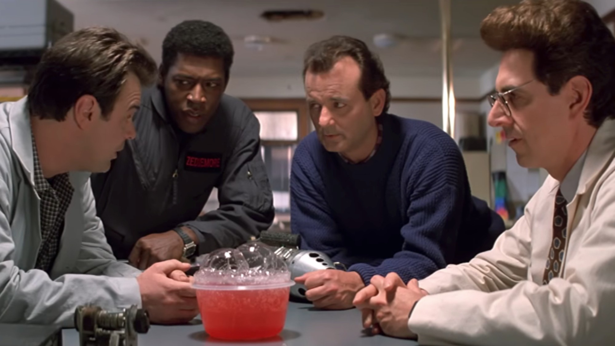 From left to right: Dan Aykroyd, Ernie Hudson, Bill Murray, and Harold Ramis standing around a plastic bucket filled with red slime in Ghostbusters II.
