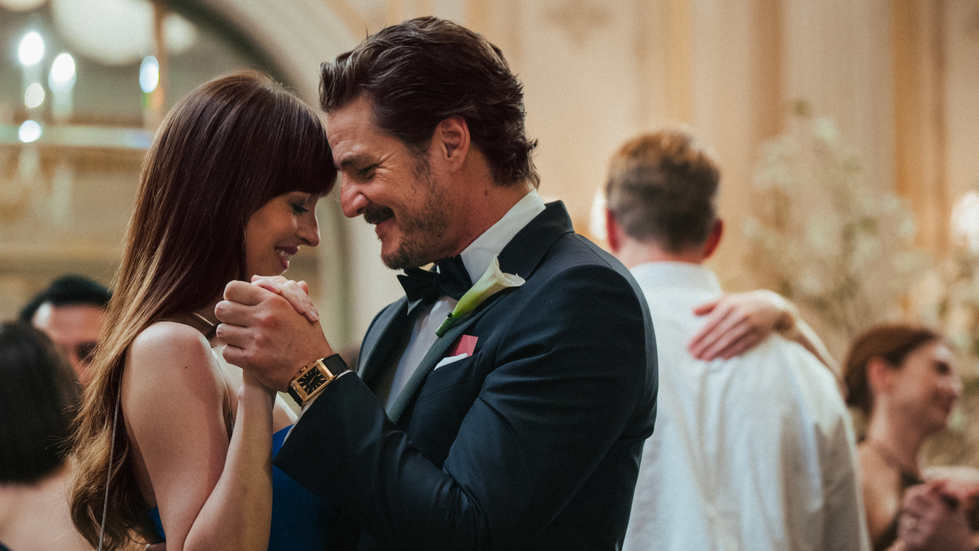 dakota johnson and pedro pascal dancing together at a wedding in materialists