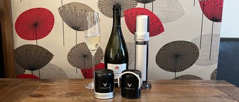 The components of the Coravin Sparkling wine preservation system next to an open bottle of prosecco and a glass of prosecco