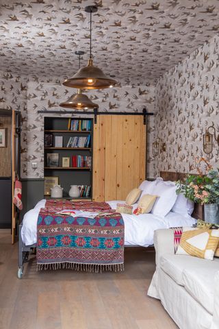 A fun and colorful bedroom with a playful bird wallpaper. With its rustic character and cosy interior, Karen and Adam Griggs’ former worker’s cottage comes into its own at Christmas