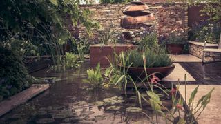 modern courtyard garden design with pond, planting and garden sculpture