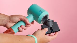 Concentrator nozzle being snapped on to Dyson Supersonic Nural hair dryer