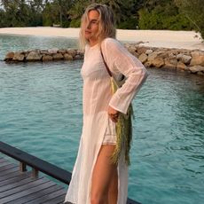 lucy wears a sheer tunic, white shorts, and black bikini