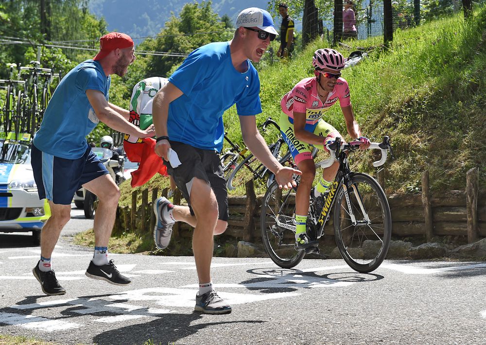 Fans run alongside Alberto Contador while he attacks.
