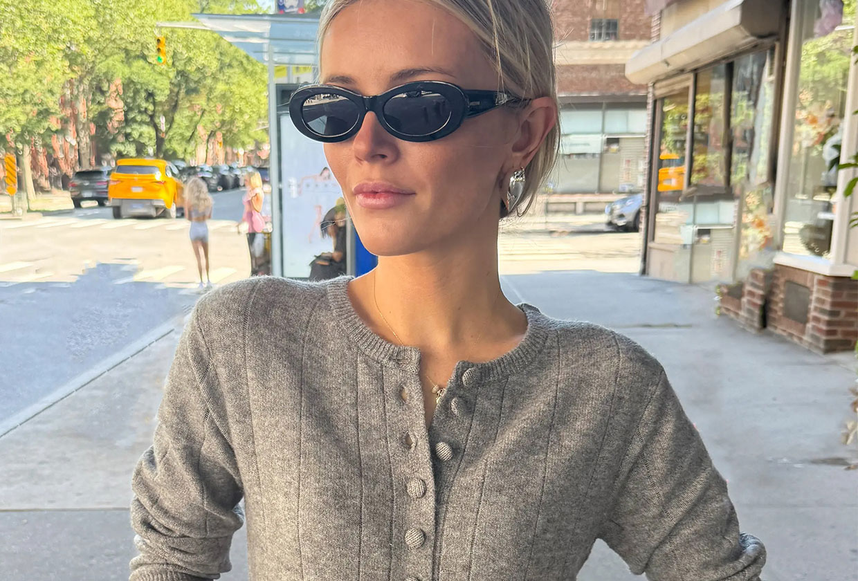 Woman wearing a buttoned-up gray cardigan.