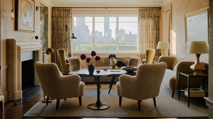 A room with matte Venetian plaster walls framed a large window with a view of Manhattan