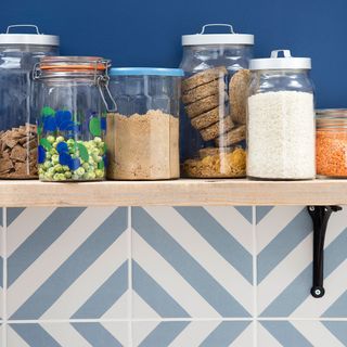 blue walled kitchen with jars on wooden shelves