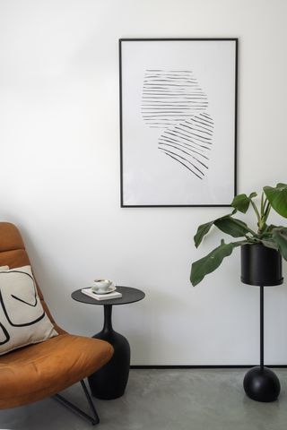 A living room with a houseplant on a black pedestal