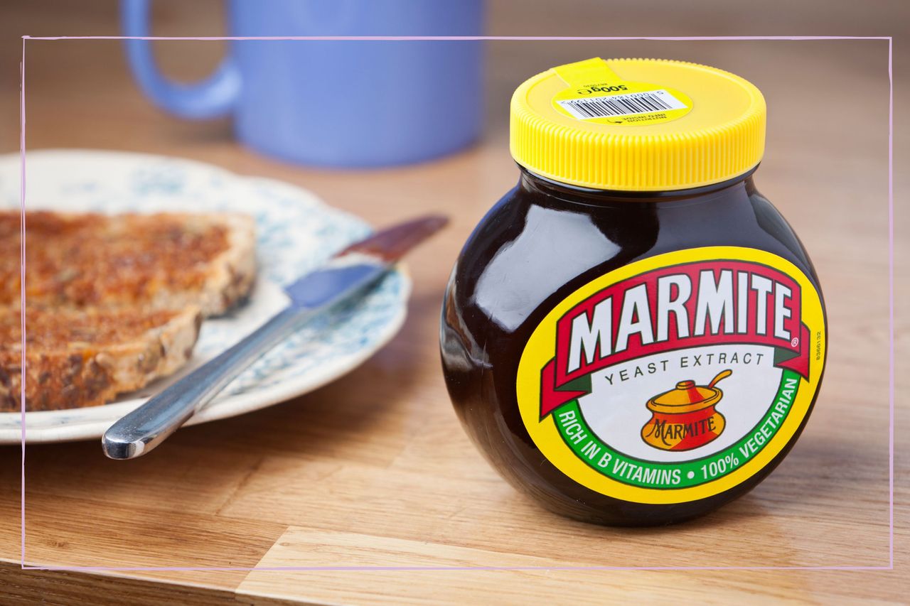 Jar of Marmite next to a plate and piece of toast