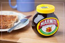 Jar of Marmite next to a plate and piece of toast