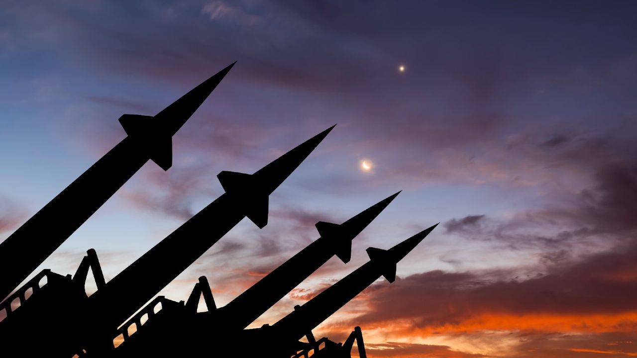 Stock photo showing a missile system with a sunset in the background