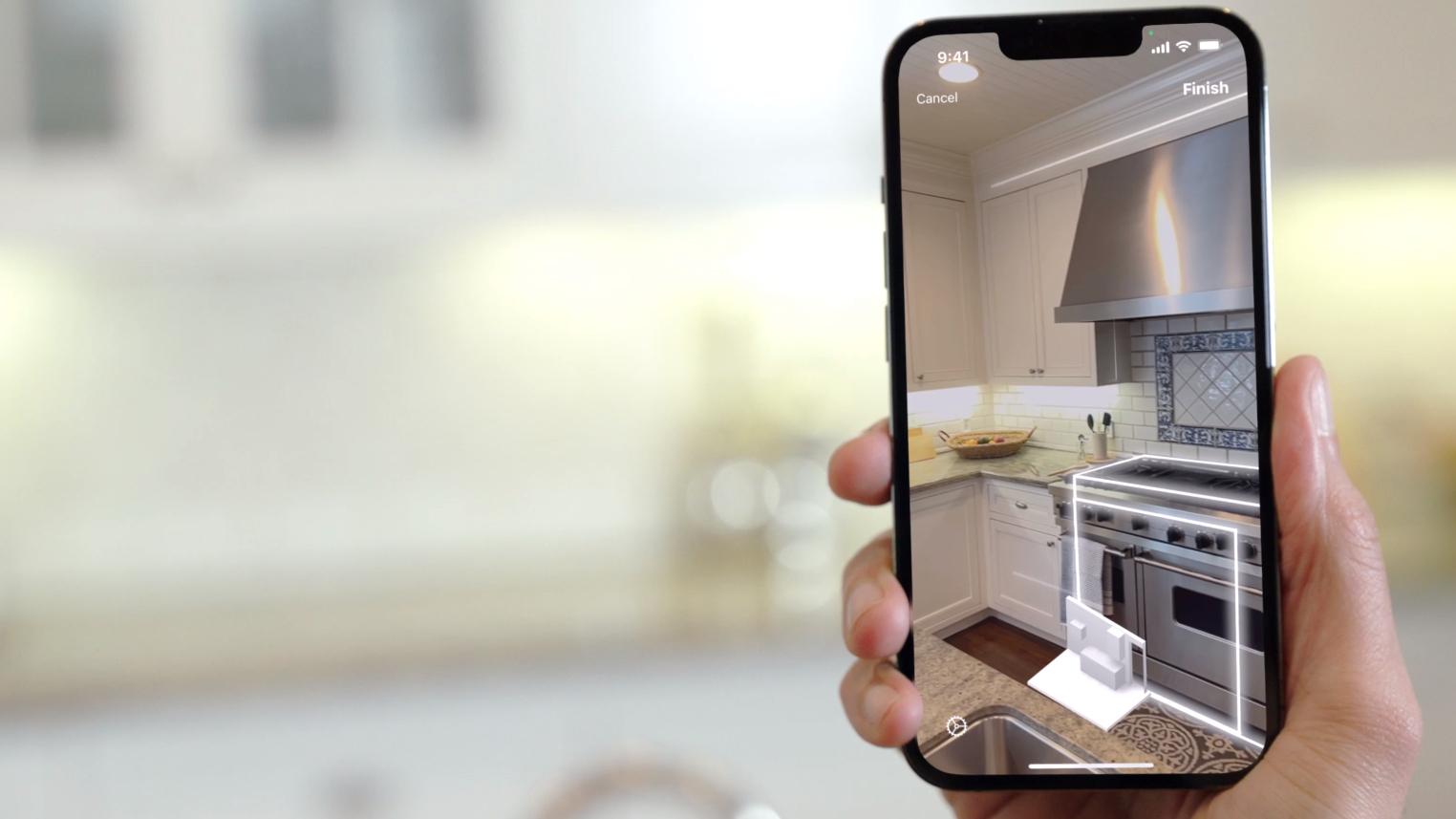 A hand holding an iPhone scanning a kitchen