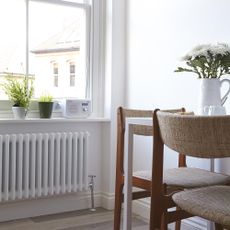 room with white coloured wooden floor and heating radiator