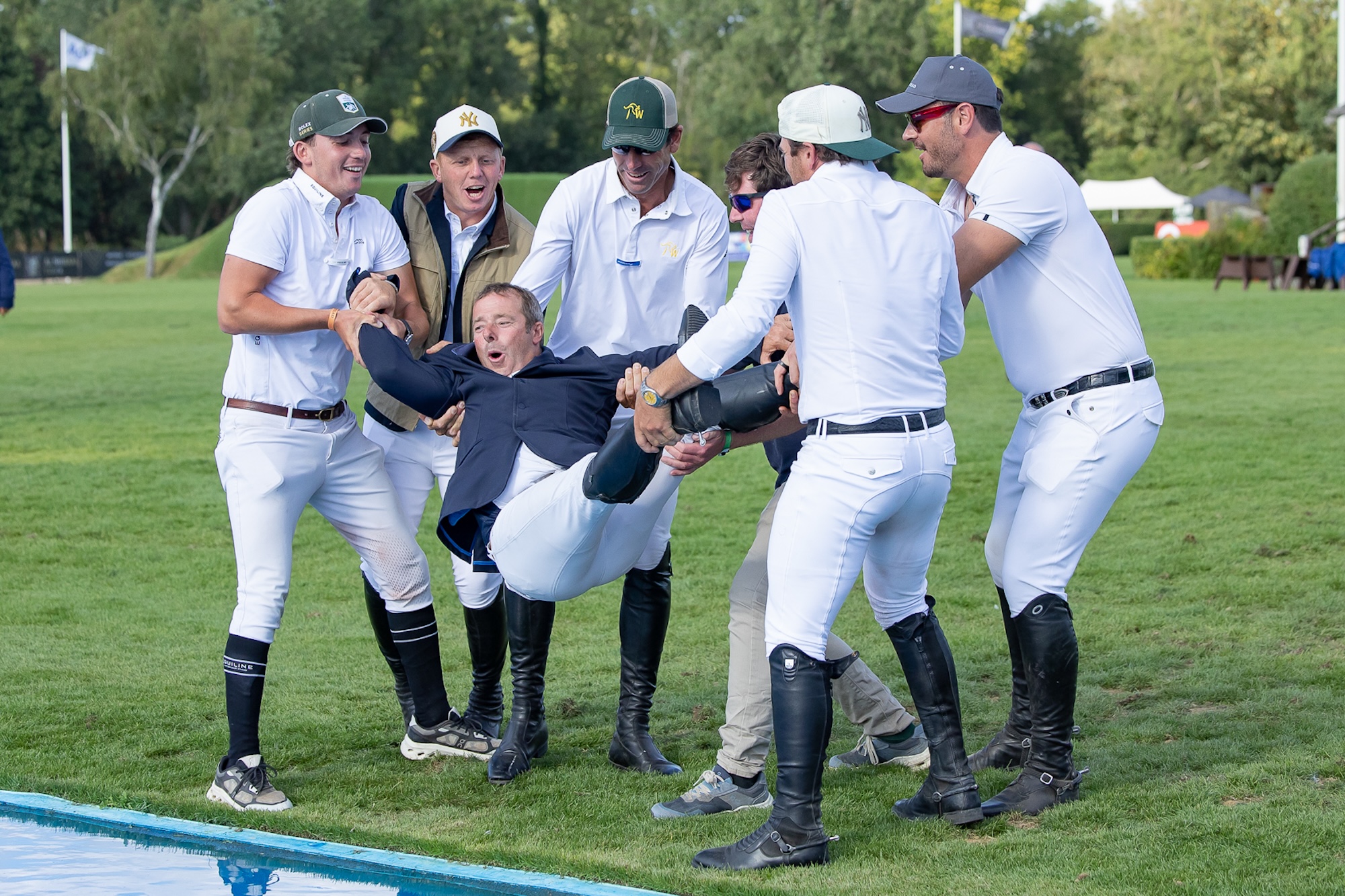 Robert Whitaker is thrown into the water jump by a group of riders