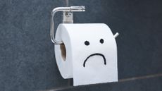 Toilet paper roll with sad face