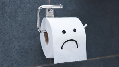 Toilet paper roll with sad face