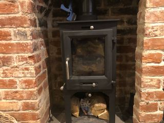 A log burner with a stove fan on top