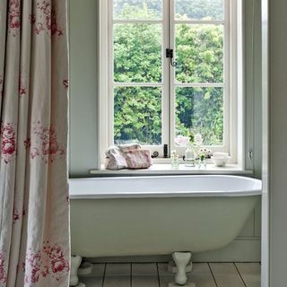 bathroom with wooden flooring and bathtub