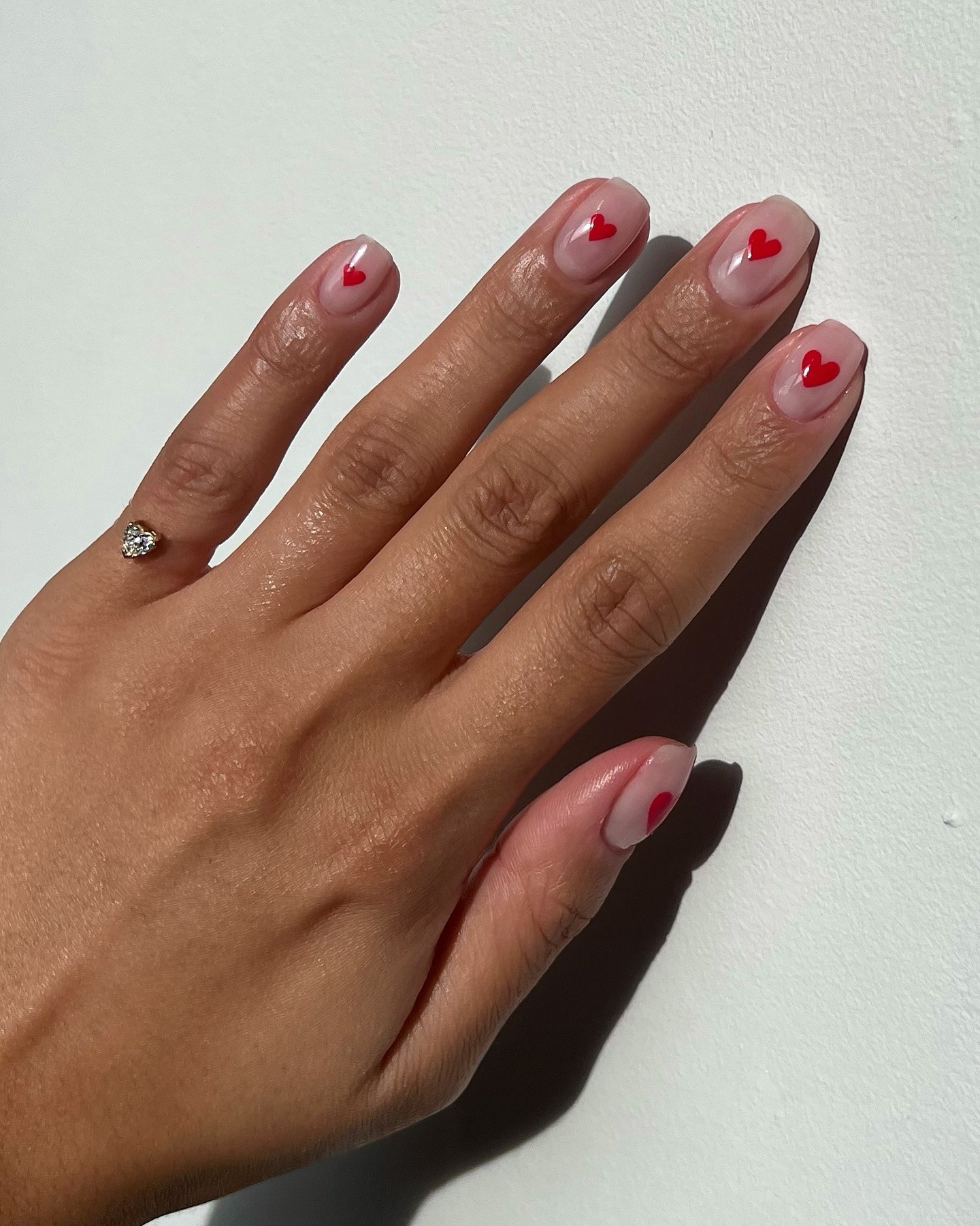 A clear manicure with minimal heart nail art