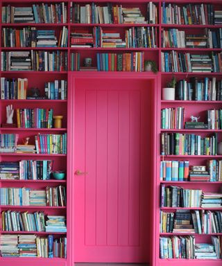 bright pink bookshelf around door