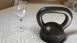 Tempur Hybrid Elite Mattress shown with a wine glass and 6kg weight during a drop test