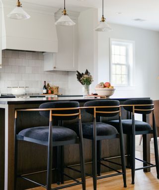 A white kitchen with a dark stained wood island