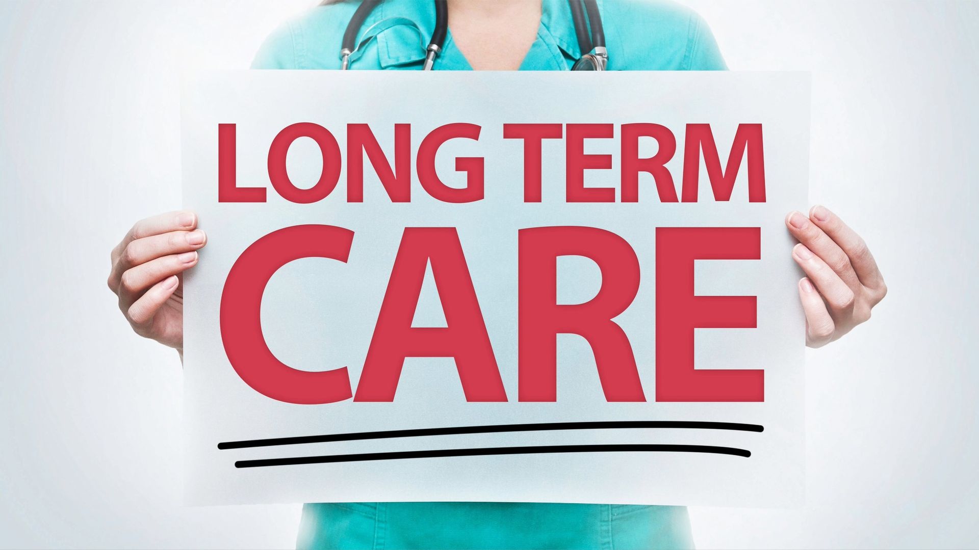 Close up of a health worker in scrubs holding up a sign reading Long Term Care