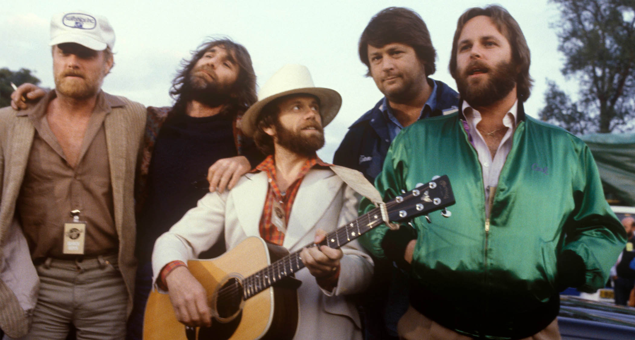 The Beach Boys circa 1980, photographed at Knebworth, with Al Jardine in the middle of the pic wearing a light suit and platying a Martin acoustic